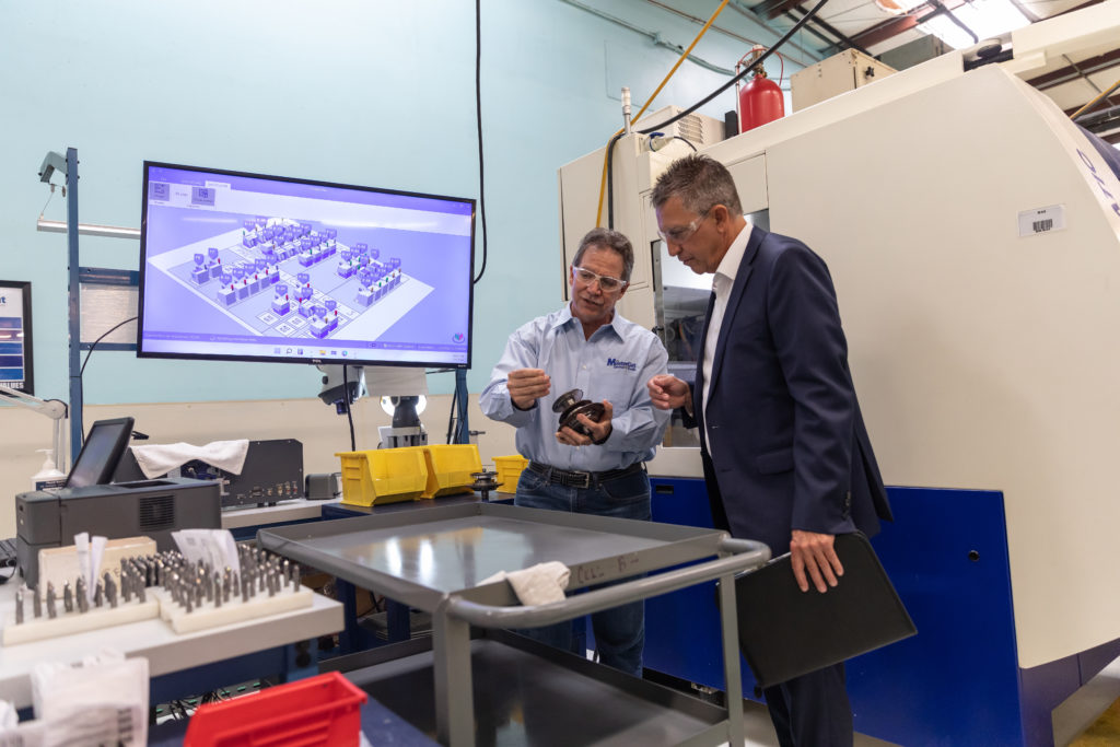 Two men in a manufacturing facility reviewing products.