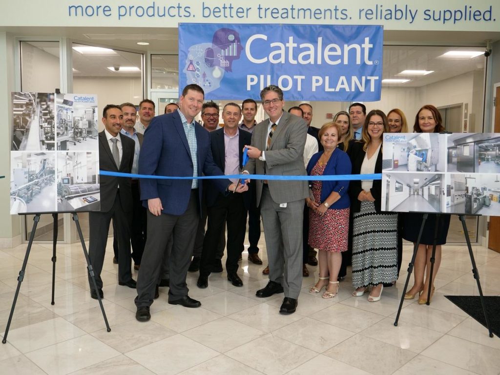 An image of people celebrating cutting a ribbon for a business expansion.