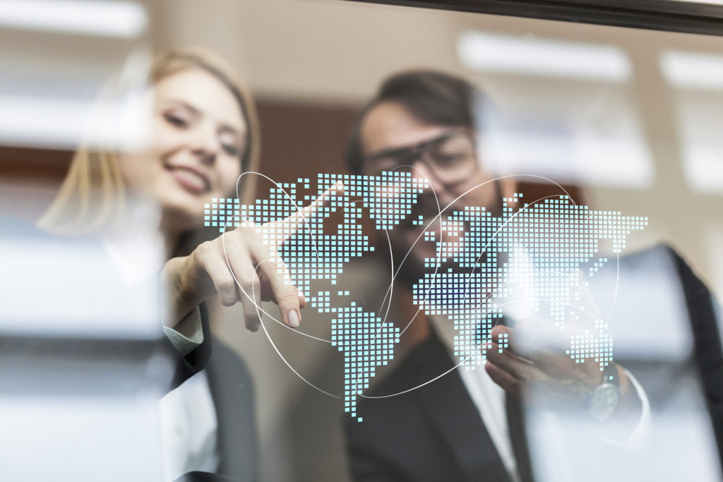 Two people pointing at a glass map.