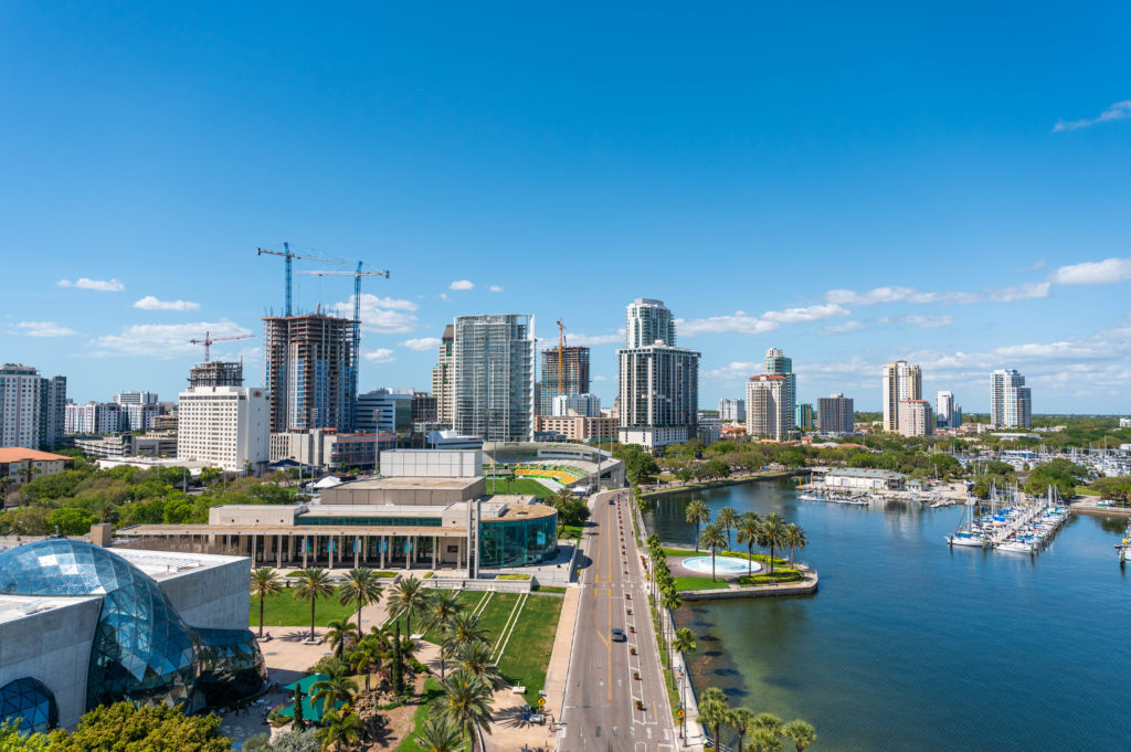 Image of an aerial view of Downtown St. Petersburg, including the Dali Museum, the Mahaffey Theater, the Al Lang Stadium, and various residential towers and commercial office buildings, hotels, and the marina.