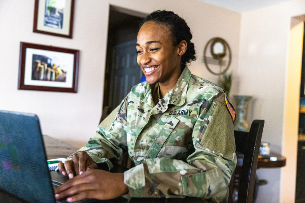 Image of a young black US Army Service member working at home.