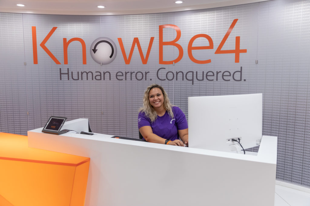 Image of a staff member at a front desk for the KnowBe4 corporation. 
