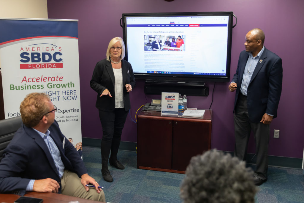 Image of SBDC Staff at Pinellas County providing a presentation to business owners in a conference room.