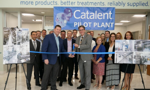 Image of employees of the Catalent company cutting a ribbon with scissors in celebration of a pilot plant.