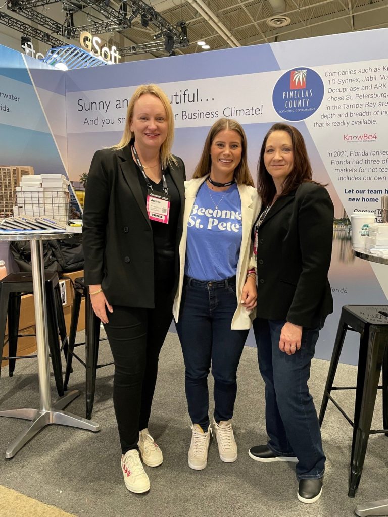 Three people standing in front of a trade show booth