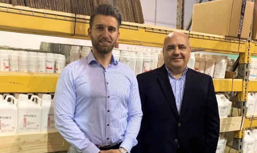 Image of two men standing in front of epoxy products on a shelf in a warehouse.