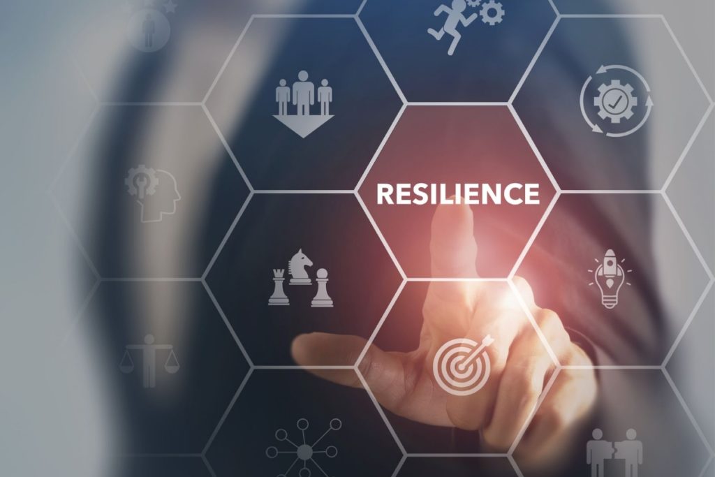 Image of the concept of resiliency, with an artistic rendering of a person touching the word resilience.