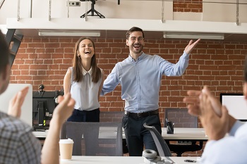 Image of two speakers before a crowd of people.