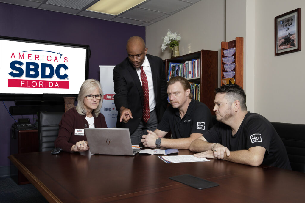 Consultants meeting with a business and all are seated at a table.